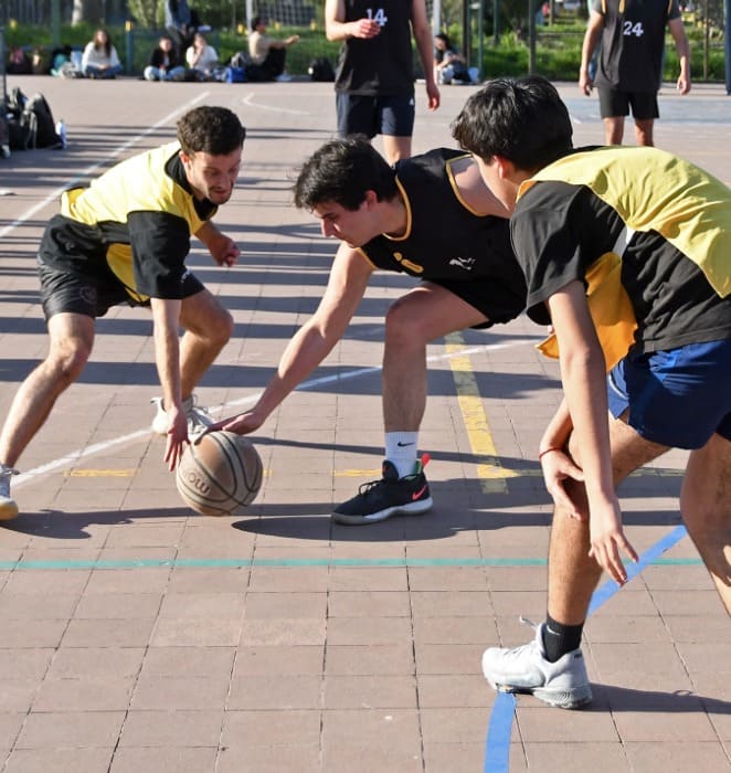 Grupo de estudiantes practican deporte al interior de cancha en campus San Joaquín.