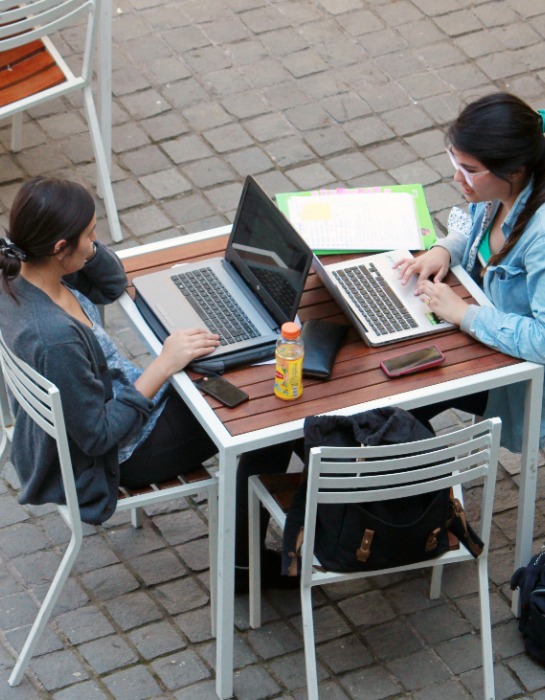 Alumnas de la UC conversan al interior del campus Casa Central.