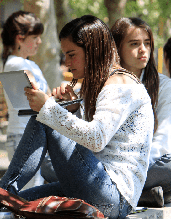 Estudiante sentada leyendo algo en el computador